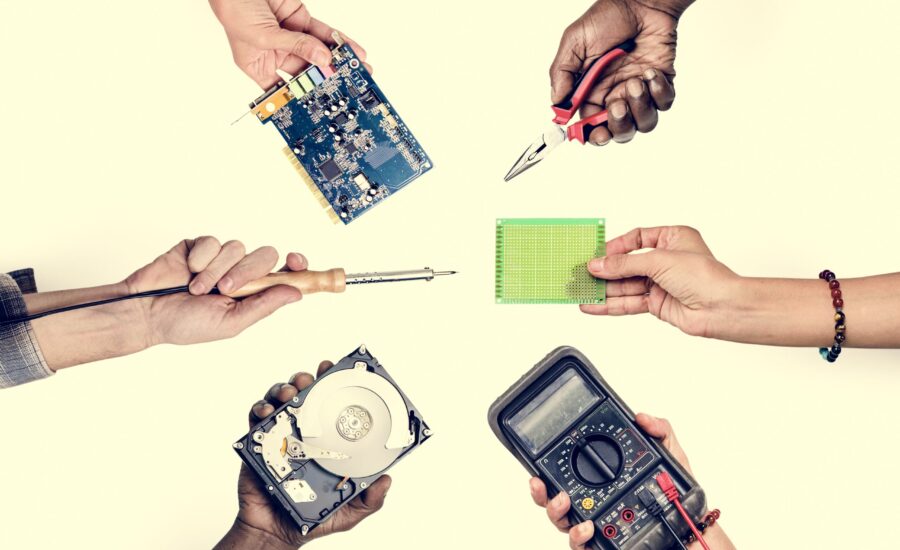 Group of hands holding computer electronics parts isolated on white